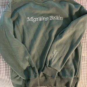 Green Sweatshirt with 'Migraine Brain' Text